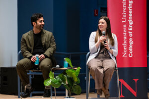 Hamed Tabkhi, PhD 2014 computer engineering, and Emily Wisniewski, BS 2015 chemical engineering, sitting on stage presenting at the Young Alumni Impact Award Ceremony.