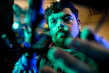 Jeffrey Lipton, assistant professor of mechanical and industrial engineering, holding his robot 