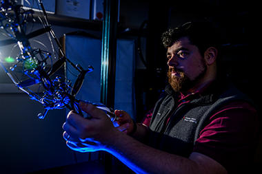 Jeffrey Lipton, assistant professor of mechanical and industrial engineering, holding his robot 
