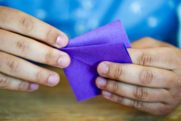 Moneesh Upmanyu folding a piece of purple paper