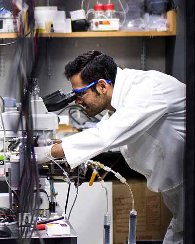 phd student in lab coat conducting research in mechanical lab