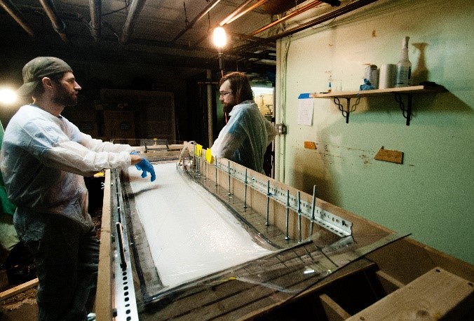 two people in factory building skateboard